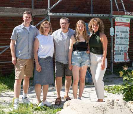 Lächelndes Hotelteam vor dem Haus